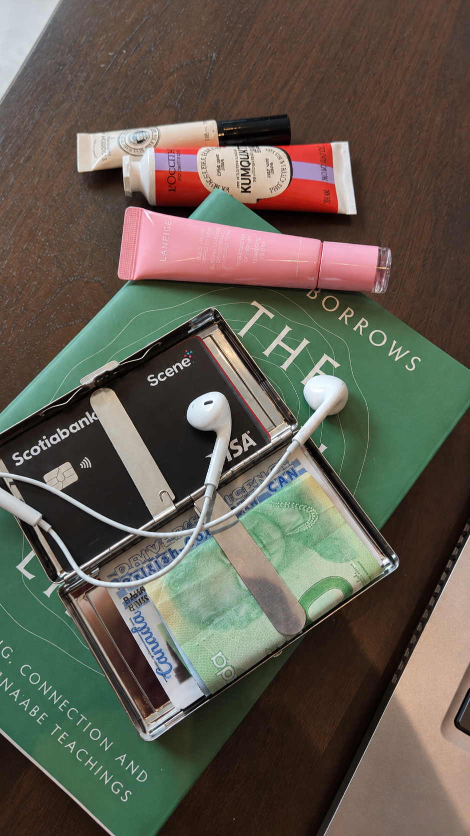 An open KIMEX metal cardholder carrying cards, notes and wired earbuds