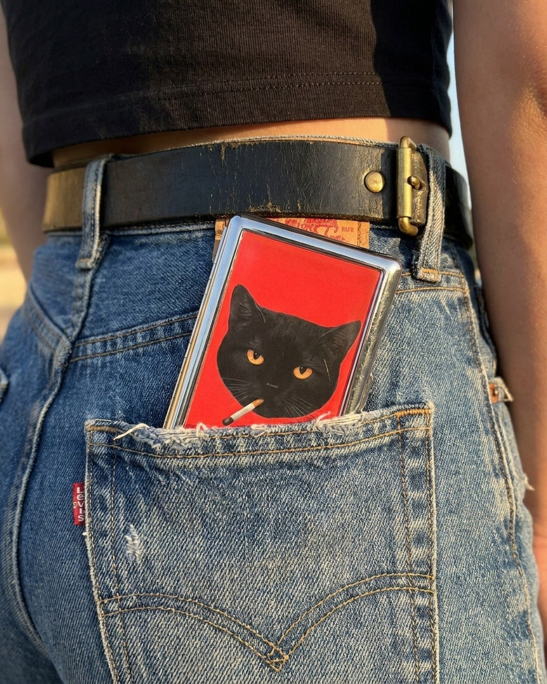 Trinket Supply metal cardholder shown in a denim back pocket